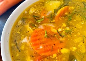 Warm vegetable soup with carrots, fresh herbs, and broth. Perfect for cozy meals.