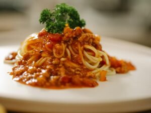 Tasty spaghetti with yummy bolognese sauce served on white plate and garnished with parsley