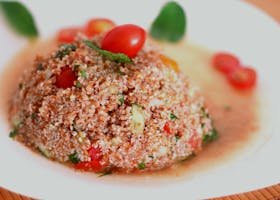Delicious tabbouleh salad featuring fresh tomatoes, mint, and bulgur wheat served on a plate.